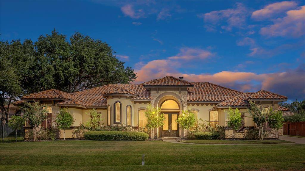 Welcome to 6010 A St, Katy, TX a Mediterranean-style design, featuring a terracotta roof and warm beige stucco exterior with lush landscaping around the property.