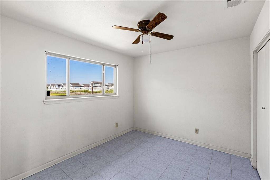 2nd bedroom with tiled flooring, ceiling fan and window.