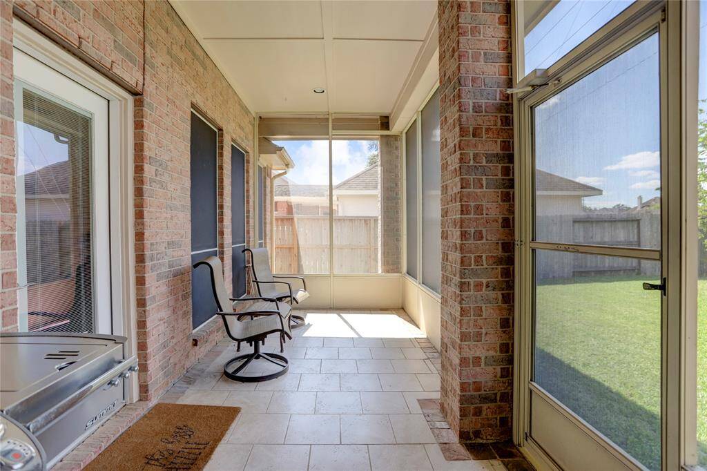 A COZY SCREENED-IN PATIO WITH SEATING AND GRILL AREA IS PERFECT FOR ENJOYING THE OUTDOORS IN COMFORT.