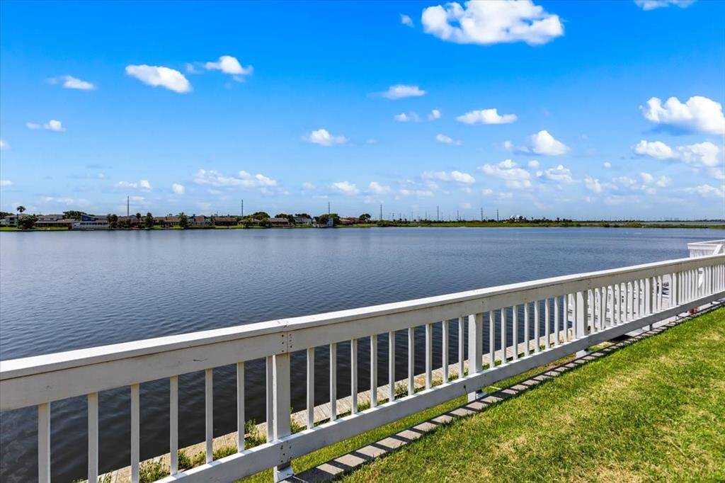This property features a serene waterfront view with a white fence bordering the bulkhead, offering a peaceful and picturesque setting.