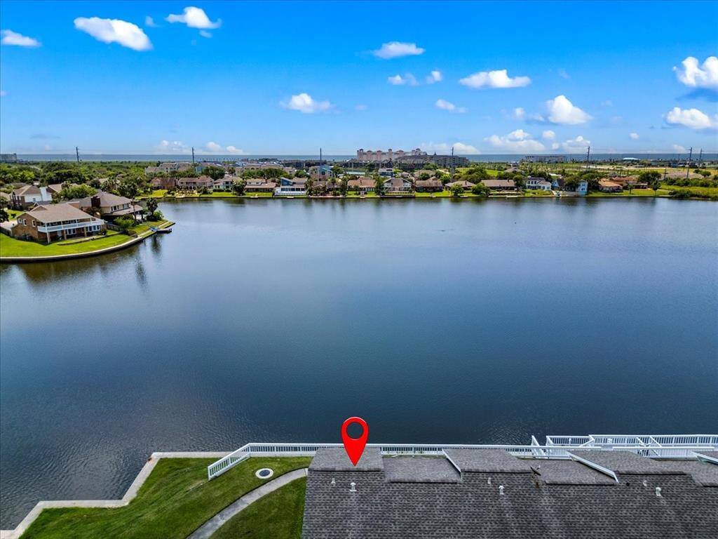 This is an aerial view of a waterfront property, showcasing Campech Cove Lake with houses along the shoreline, indicating a peaceful and scenic living environment.