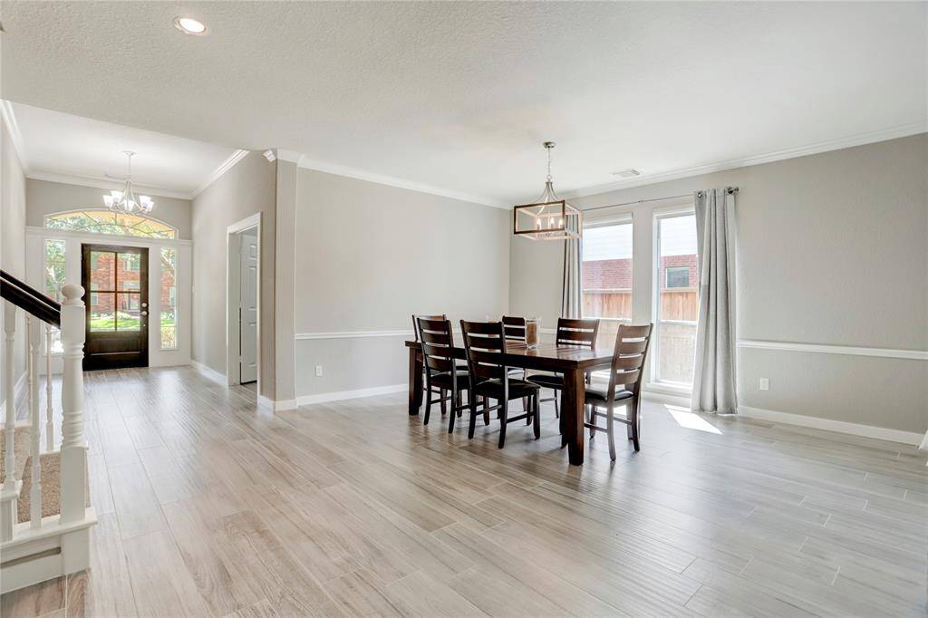 BEAUTIFULLY UPDATED LIGHTING AND FLOORS CREATE AN ELEGANT DINING SPACE.