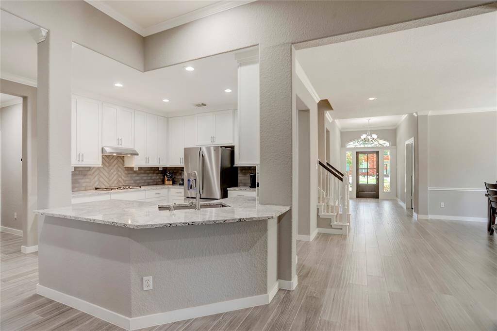 SPACIOUS FIRST FLOOR FEATURES BEAUTIFUL WOOD-LOOK TILE FLOORING THAT SEAMLESSLY TIES EACH ROOM TOGETHER.