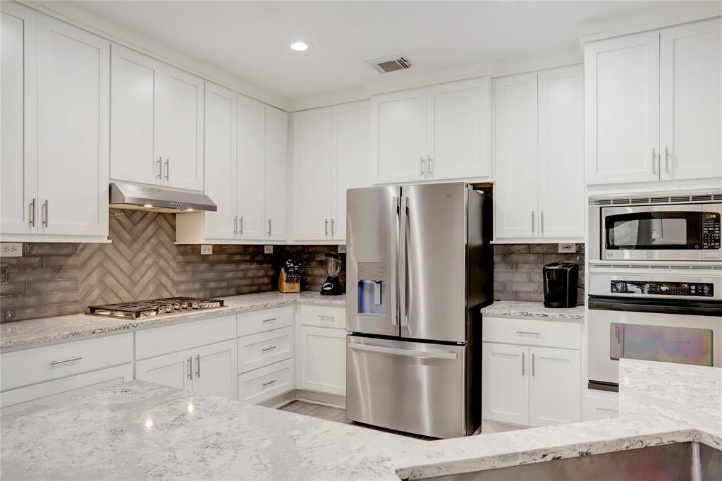 STAINLESS-STEEL APPLIANCES, LIKE THIS 5-BURNER GAS STOVE, FRIDGE AND OVEN COMPLETES THIS CHEF-FRIENDLY KITCHEN.