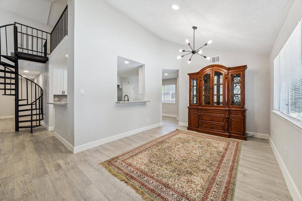 The formal dining room features a modern light fixture and recessed lighting, along with a breakfast bar.