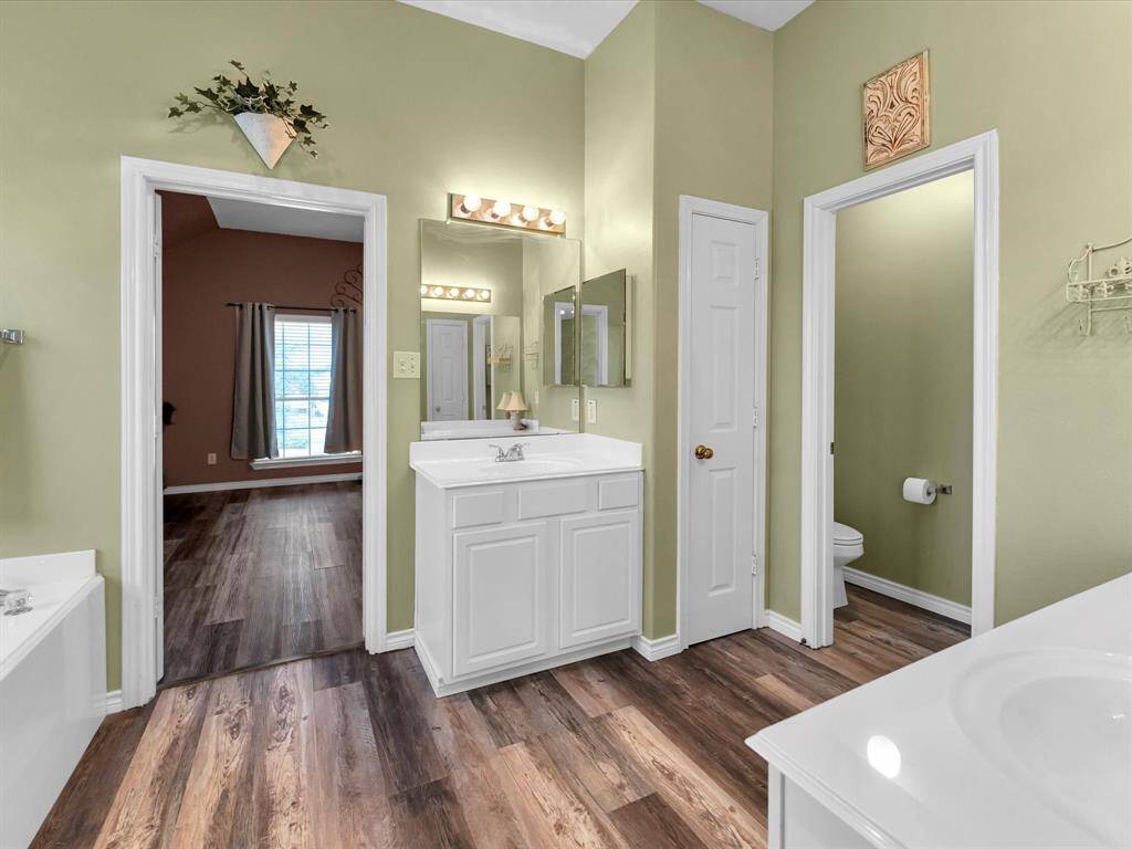 Experience spa-like luxury with this ensuite master bath, featuring dual vanities, a standalone shower, and a relaxing jetted tub. Privacy is ensured with a separate room for the toilet.