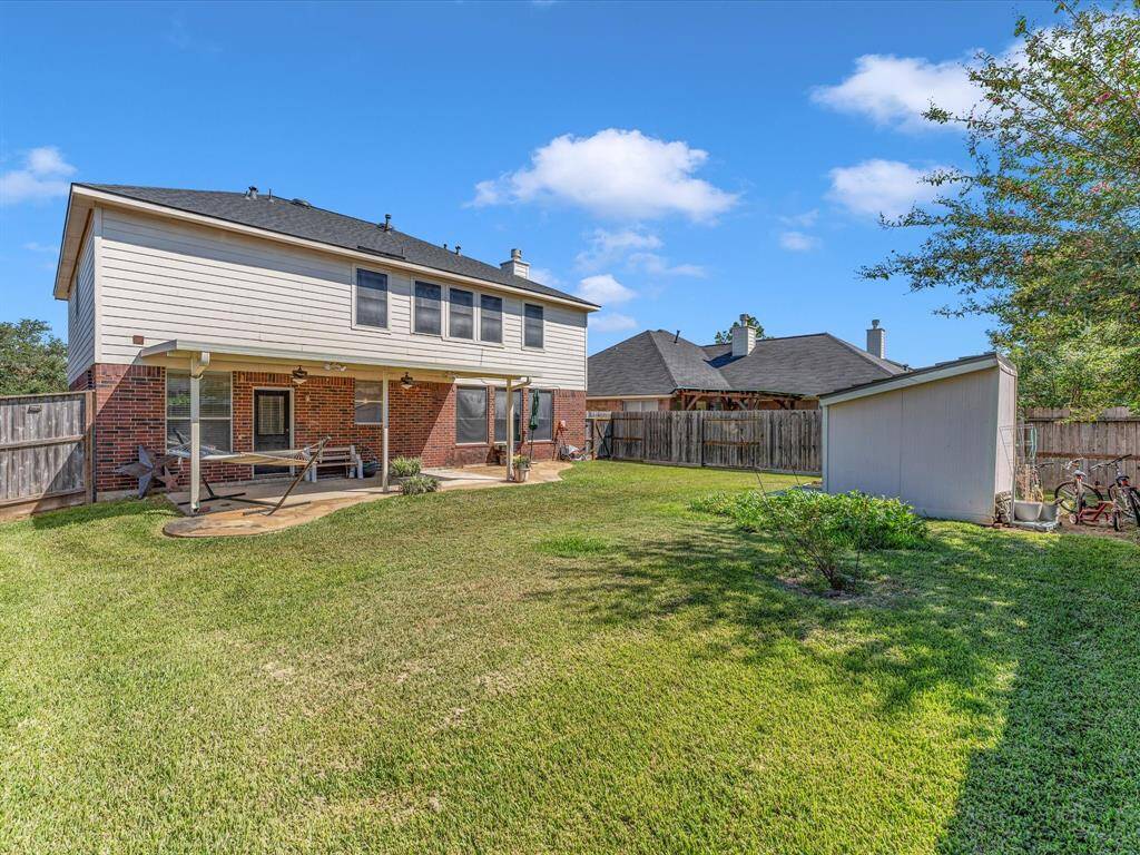 This backyard is not shy on space or luscious green grass! Don't miss the planter bed with watermelon growing and the convenient storage shed.