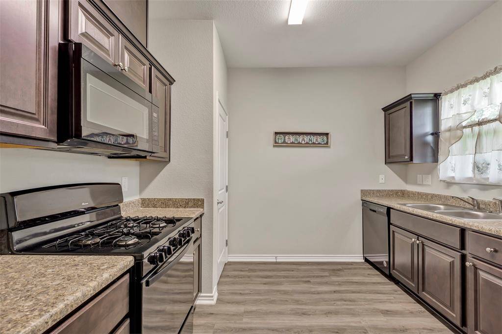 This kitchen boasts sleek granite countertops, double sinks for added convenience, and a pantry discreetly tucked behind a closed door, offering ample storage space for all your food and appliances!