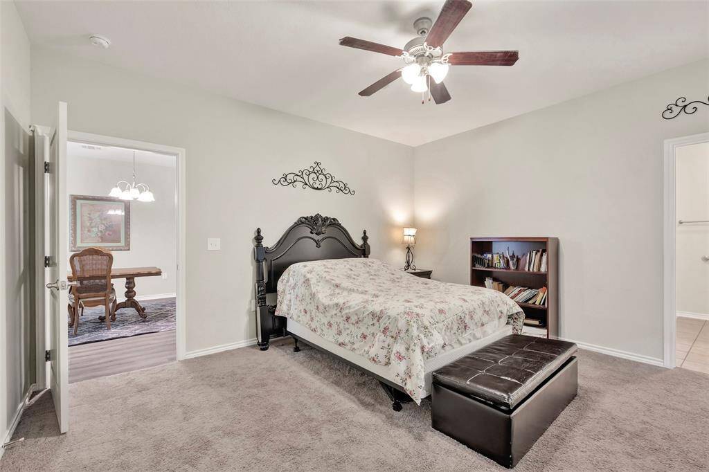 The spacious main bedroom features cozy carpeted flooring and is conveniently located just across from the dining area.