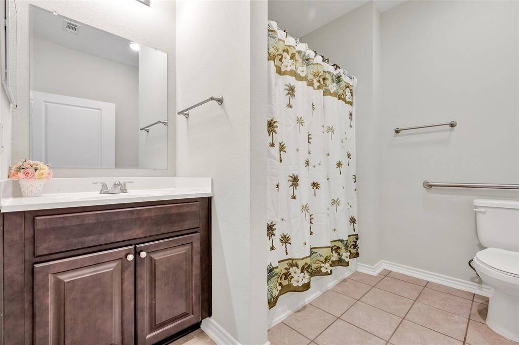 The main bathroom is equipped with a convenient tub and shower combo, complemented by a single sink vanity with storage space beneath.