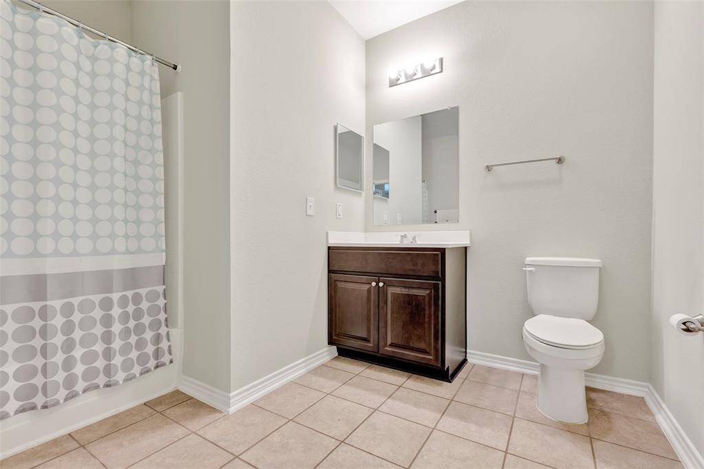 The secondary bathroom mirrors the features of the primary bathroom, offering a tub and shower combo for added convenience.