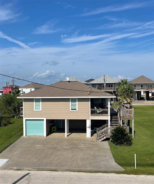 Welcome to this inviting coastal retreat featuring a spacious driveway, an integrated garage, and a charming upper-level balcony promising serene outdoor living.