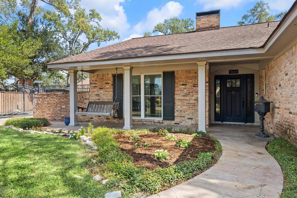 Inviting front porch with swing. Automatic driveway gate leads to 3 car garage, carport and extra parking
