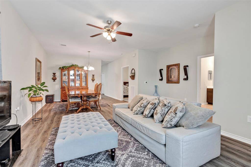 A full view of the living room and dining area, along with a glimpse of the entrances to the main bedroom and kitchen, showcasing the home's thoughtful and accessible layout.