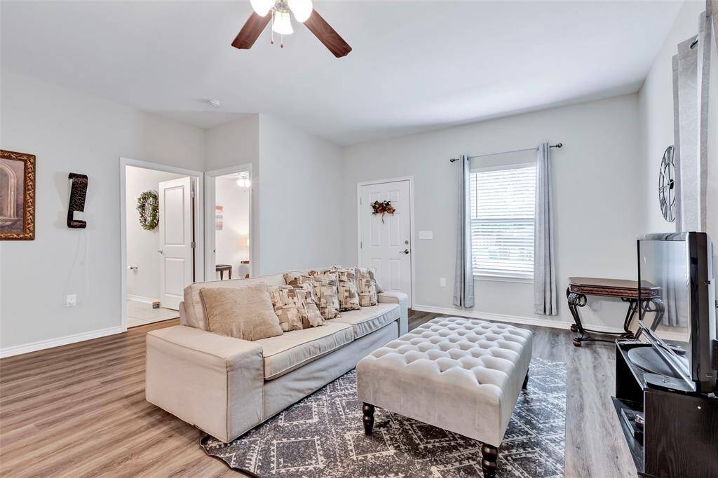 A showcase of the living room, offering a view of the front door from inside, along with the entrance to the secondary bedroom and bathroom, enhancing the home's functional and welcoming layout.