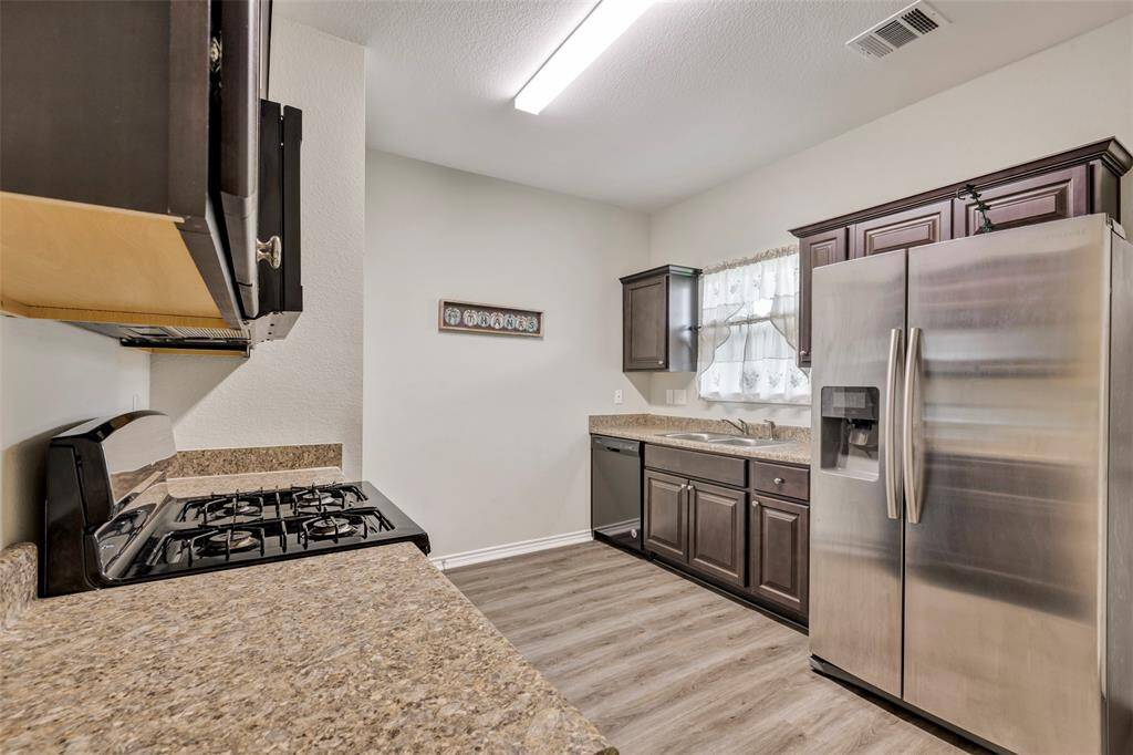 The kitchen, conveniently located behind the dining room, features stainless steel appliances that are ready for all your culinary needs.