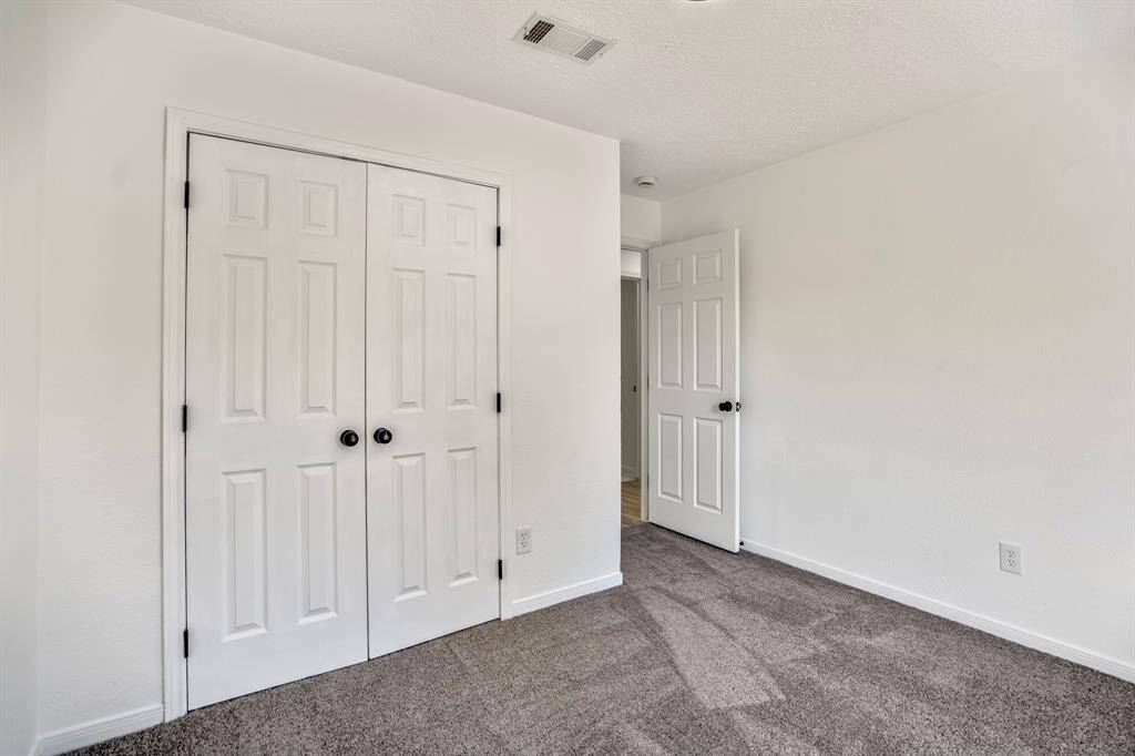 This second bedroom offers a fresh, inviting feel with brand-new carpeting and a spacious closet accented by sleek black hardware. The clean, modern finishes make this room both functional and stylish.