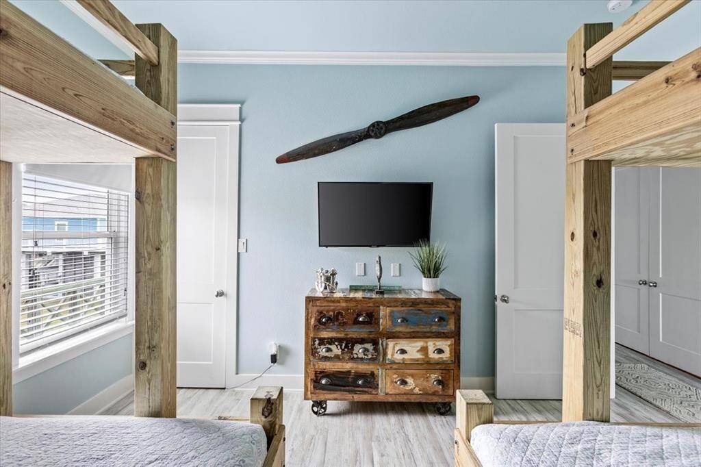 Guest bedroom with custom built double bunkbeds, TV, and spacious closet. This room can fit 6 guests.