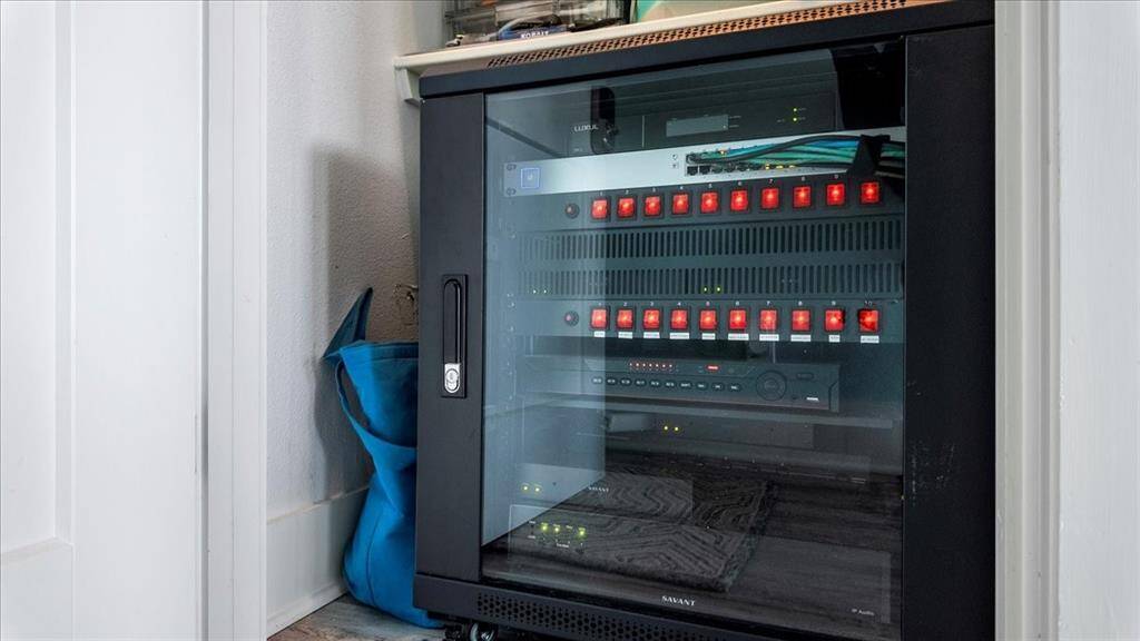 Owner's closet off the main hallway features a Savant rack that controls the house's lighting, speakers, cameras, and TVs. These features can be controlled remotely or in house from your smart phone.