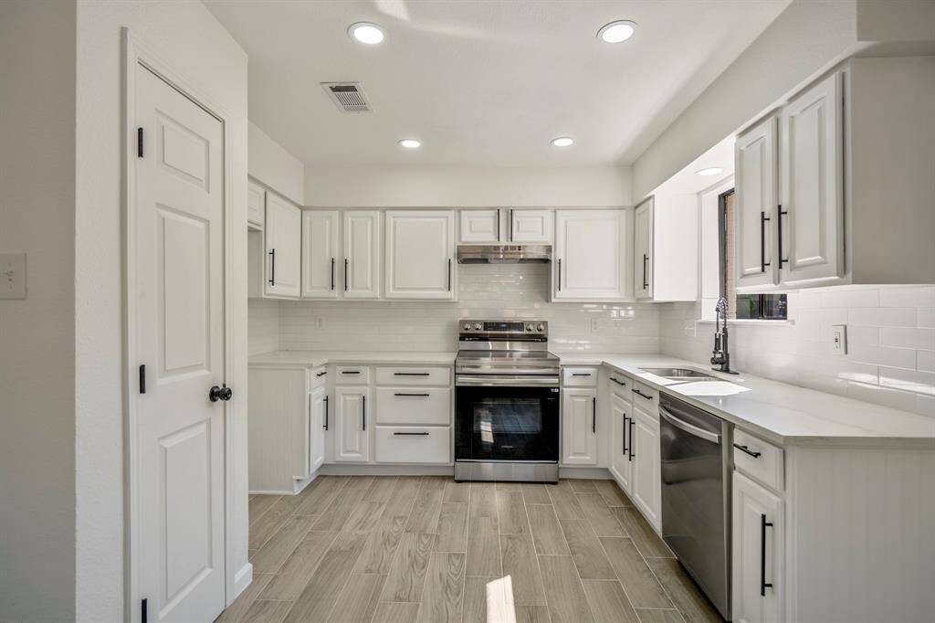 Another captivating view of this beautiful kitchen, designed to showcase its full elegance and functionality. The white shaker cabinets, accented by matte black hardware, continue to impress, while the gleaming stainless steel Samsung appliances add a touch of modern luxury. This angle perfectly captures the kitchen in its entirety, highlighting its impeccable design and spacious layout.
