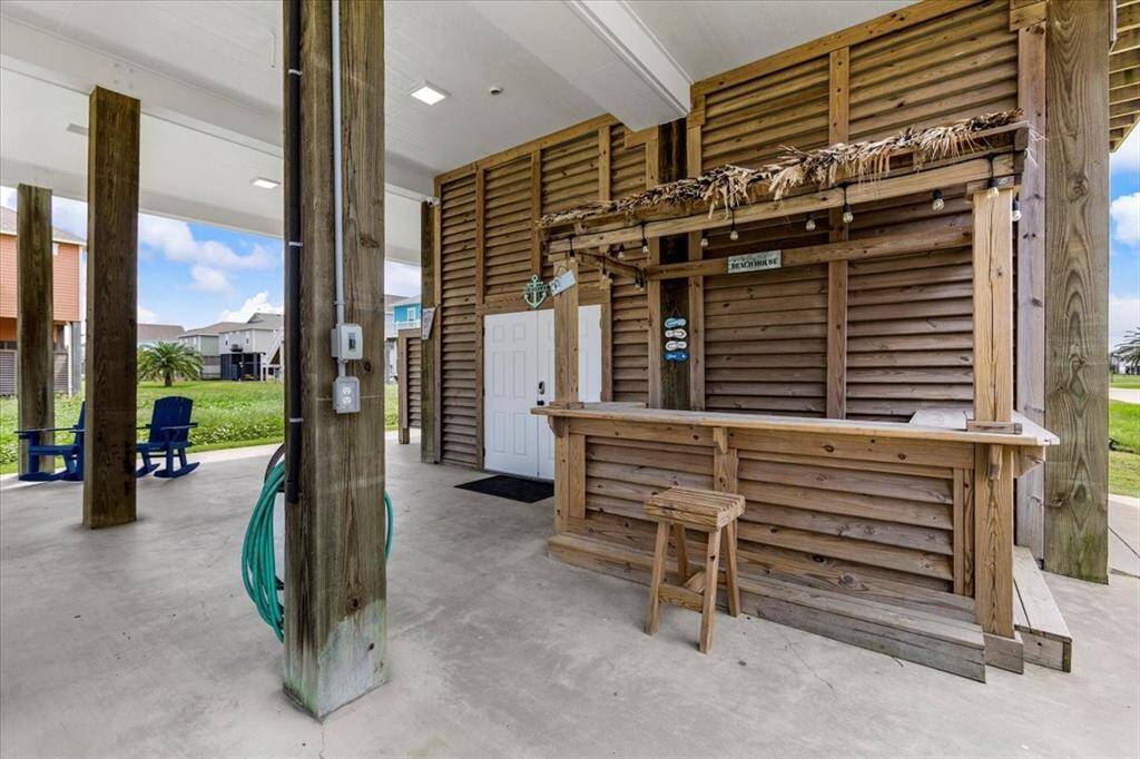 Downstairs outdoor area consists of a windstorm garage, bar area, and outdoor shower.