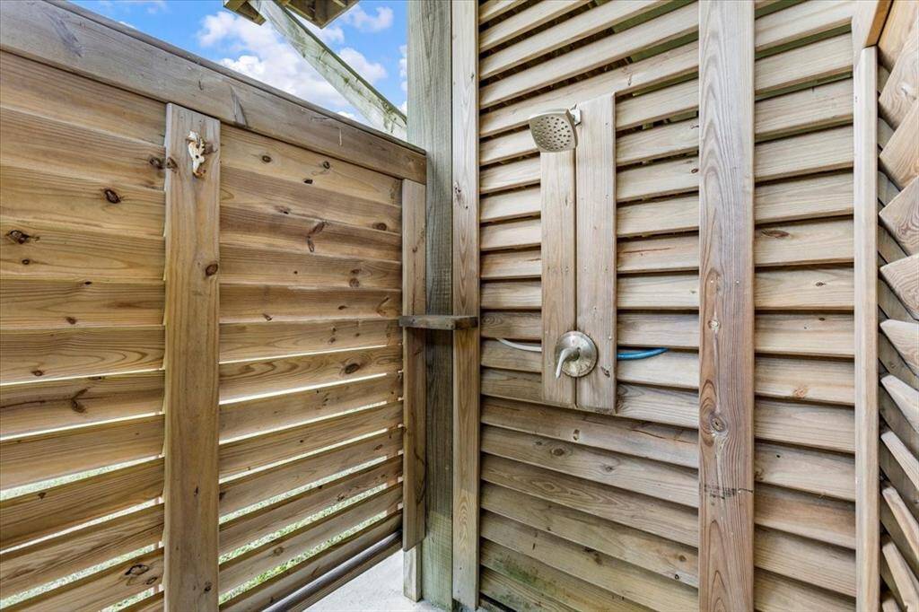 Downstairs outdoor area consists of a windstorm garage, bar area, and outdoor shower.