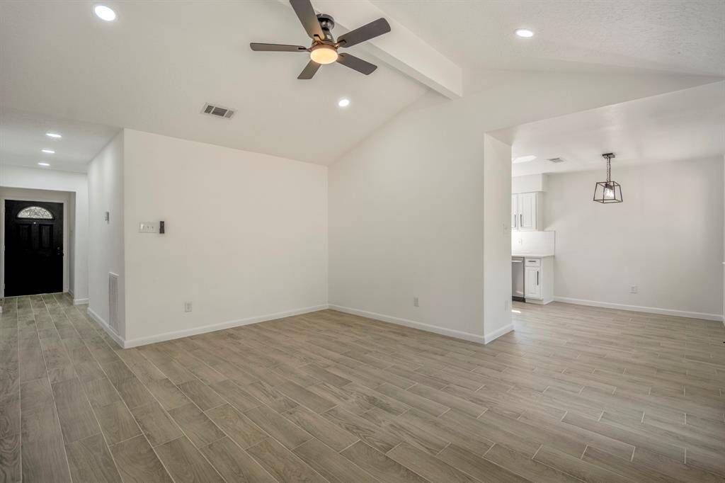 This inviting living room features beautiful wood-look tile, offering the warmth and charm of natural wood with the added benefits of durability and easy maintenance. A perfect blend of modern style and practicality, the space also includes a sleek ceiling fan equipped with a convenient remote control, allowing for effortless adjustments without ever having to leave your seat.