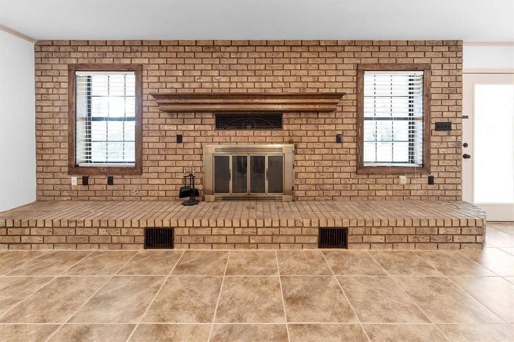 Cozy brick wood-burning fireplace in a warm living room.