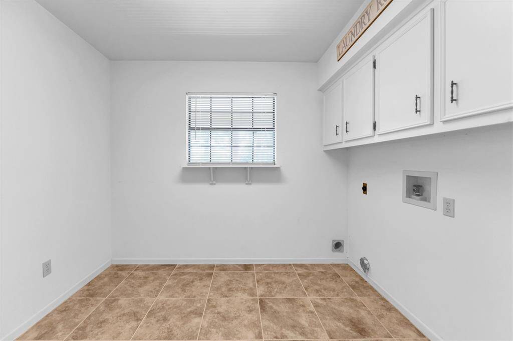 Spacious laundry room with overhead cabinets