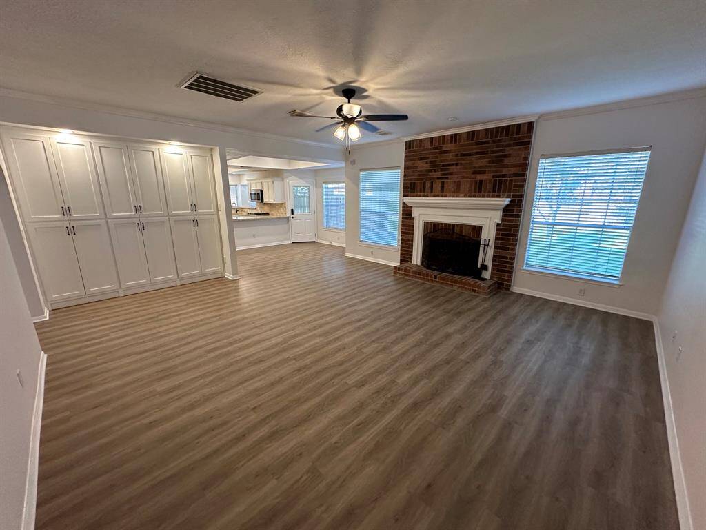 Spacious family room with cozy, brick fireplace.