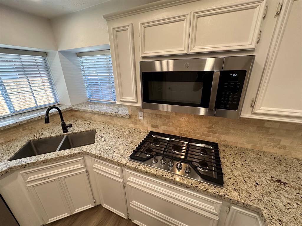 Undermount stainless steel sink, gas cooktop, microwave.