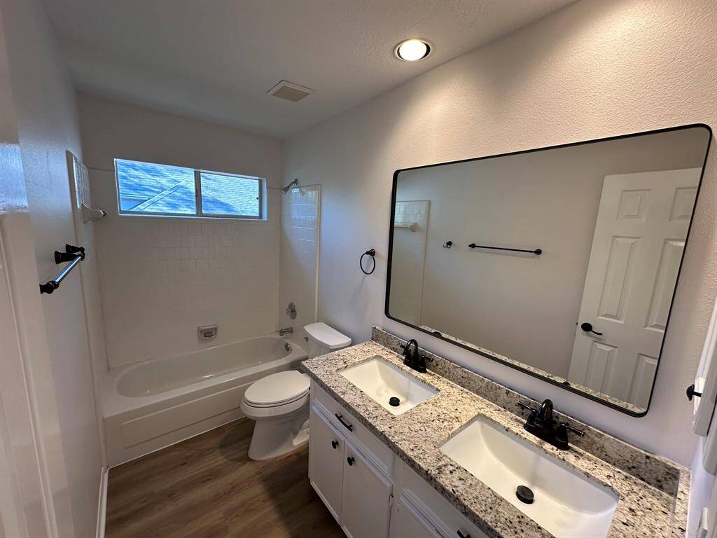 Secondary bathroom with granite counter, double undermount sinks.