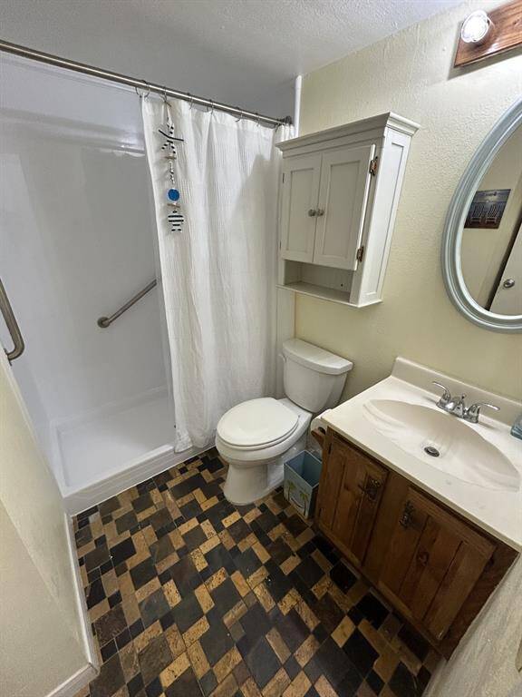 Bath with walk-in shower stall.