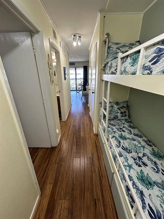 Looking from the front door of the condo with the bunk beds on the right and the private bedroom on the left. Beautiful wood plank floors.
