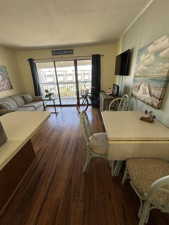 Dining area on the right and kitchen/breakfast bar on the left with balcony in the background.