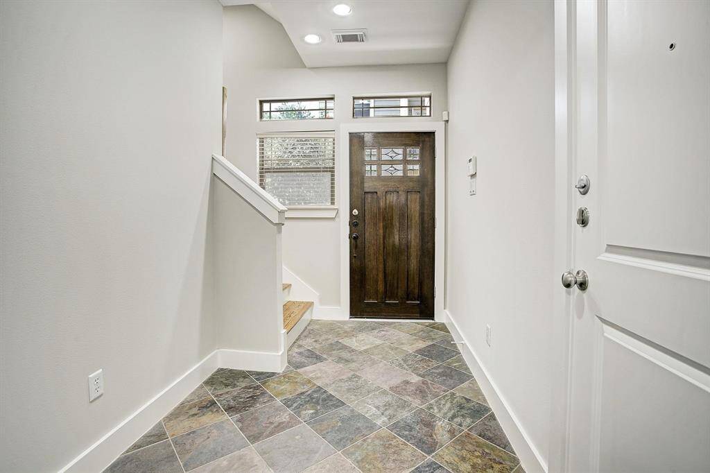 Foyer has Brazilian slate floors and has entrance from garage as well as entrannce to bedroom with full bath and easy access to back yard area