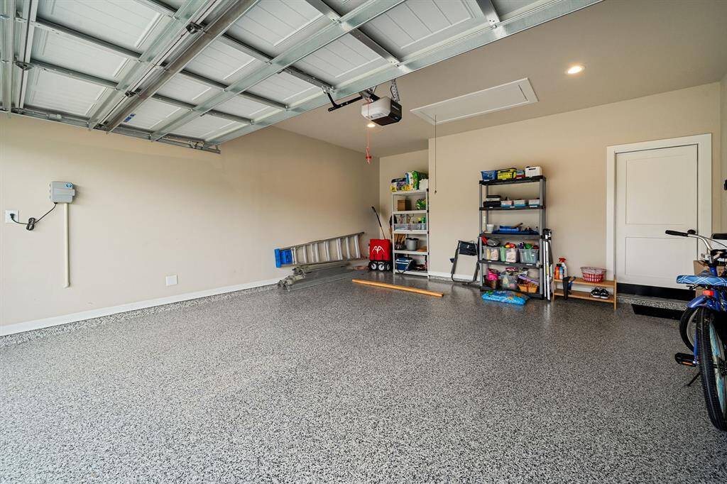 This is a clean and spacious garage with a custom speckled epoxy floor with ample room for parking and storage.