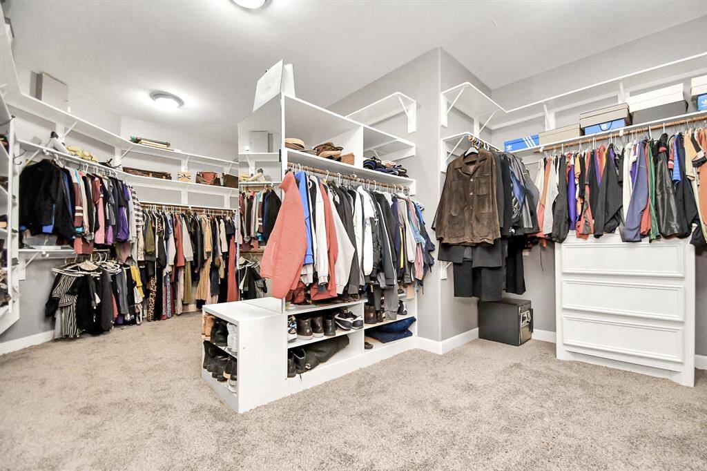 The expansive primary closet is a luxurious masterpiece, designed with functionality in mind. Featuring high ceilings and additional shelving this impressive space is thoughtfully divided into two sides, offering ample room for all your wardrobe needs. The custom-built dressers add a touch of sophistication, while a dedicated shoe area provides the perfect showcase for your collection.