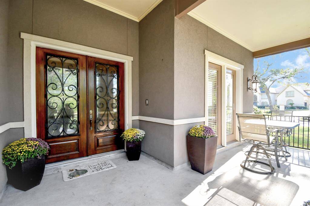 As you approach the grand entrance of this stunning luxury stucco home, you’re welcomed by an impressive set of double doors that exude elegance and sophistication. Flanking the entrance is a charming, thoughtfully designed sitting area, perfect for enjoying tranquil mornings or evening conversations.