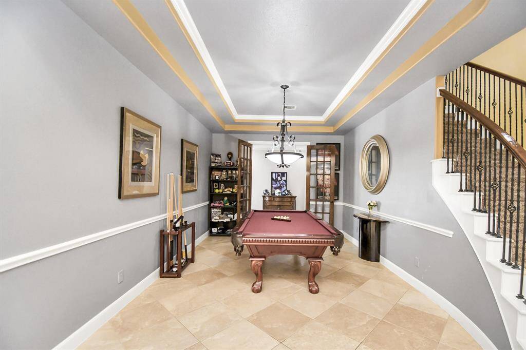 The home features a versatile formal dining room, currently transformed into a billiard room, making it a standout space for entertaining and leisure. This sophisticated setup includes a high-end pool table, perfectly blending luxury and fun. Whether you envision it as a space for refined dinner parties it will cater to all your needs.