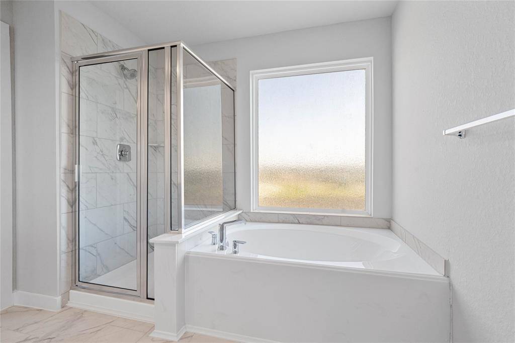 Additional view of the primary bathroom featuring dark framed walk-in shower with tile surround, separate garden tub for soaking after a long day.