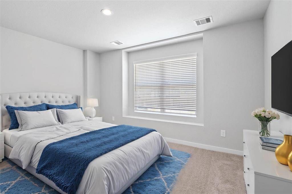 This secondary bedroom features custom paint, plush carpet, and a large window with privacy blinds!