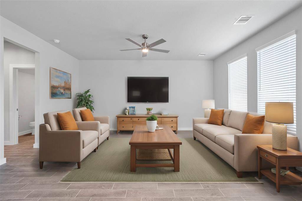 This light and bright spacious family room is the perfect layout for entertaining or just relaxing! Whether it's simply a night in or entertaining family and friends, this home has ample open space for everyone to enjoy! Featuring large windows with blinds, ceiling fan, and wonderful access to your gorgeous kitchen!