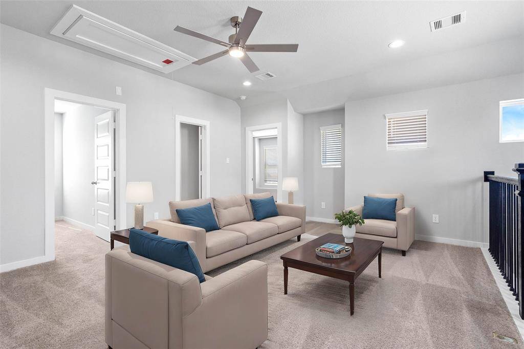 Come upstairs into this spacious second floor. This space features plush carpet, ceiling fan, recessed lighting, custom paint, and wrought iron stair railing.