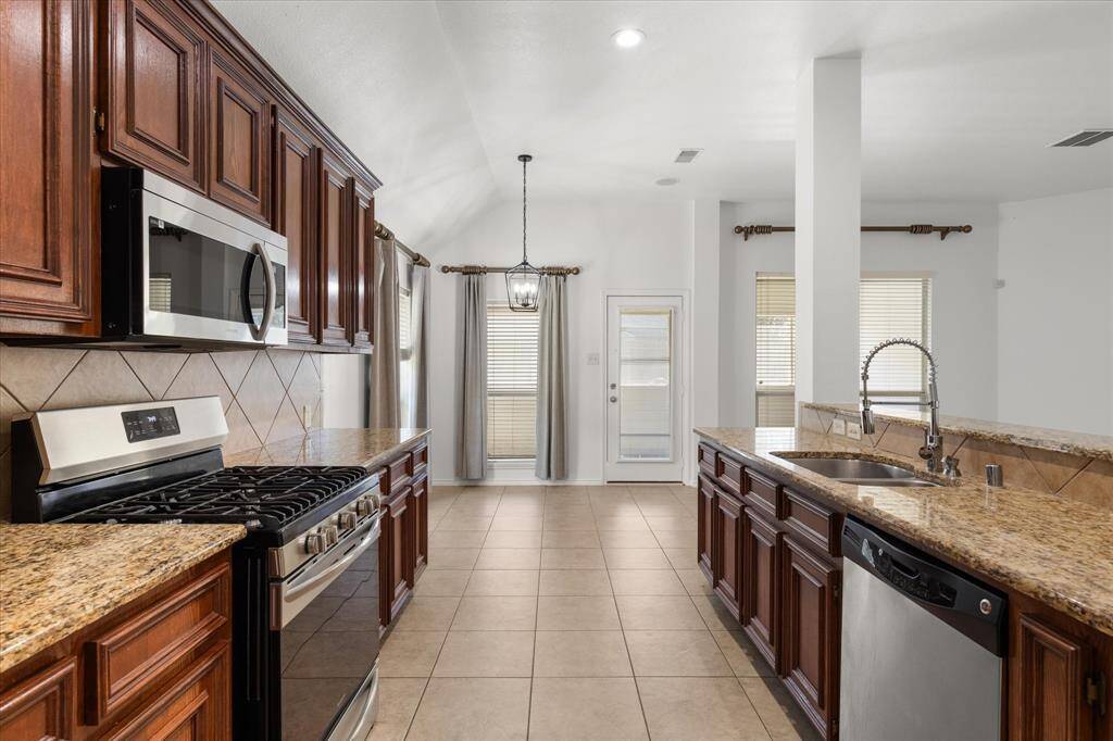 This kitchen features 42-inch cabinetry, granite countertops, stainless steel appliances, and a spacious layout.