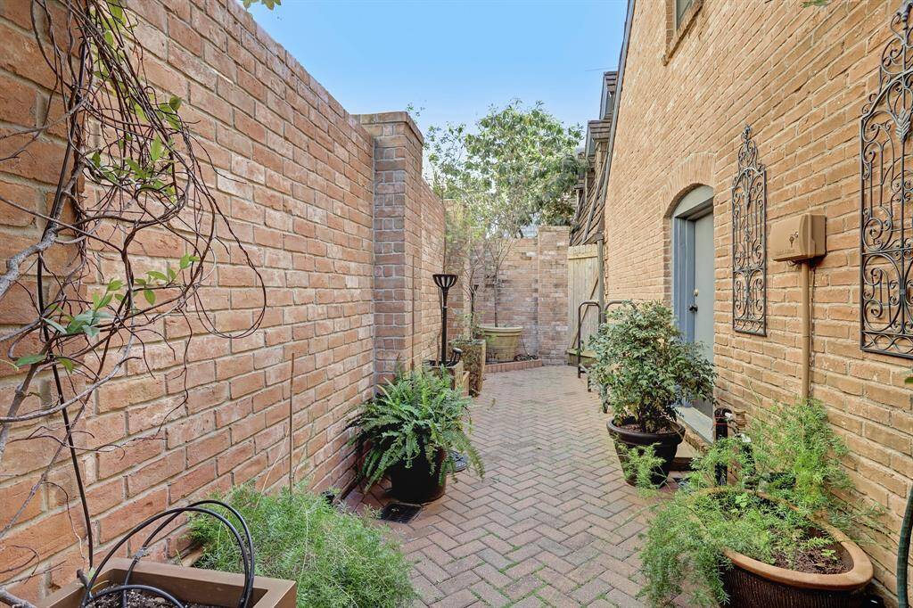 Charming Enclosed Patio with brick pavers and walls.