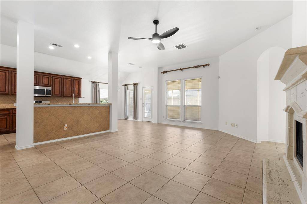 another view of the family room. The photo shows a spacious and bright living room with large windows allow for natural light, and the neutral color palette offers a blank canvas for personalization.