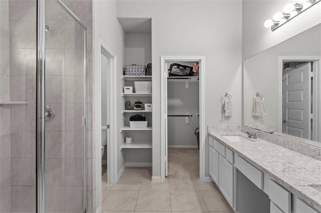 Double vanity in primary bathroom with spacious shower