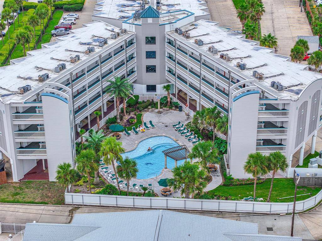 Get access to a spacious outdoor pool area surrounded by palm trees and lounge chairs, offering a resort-like atmosphere.