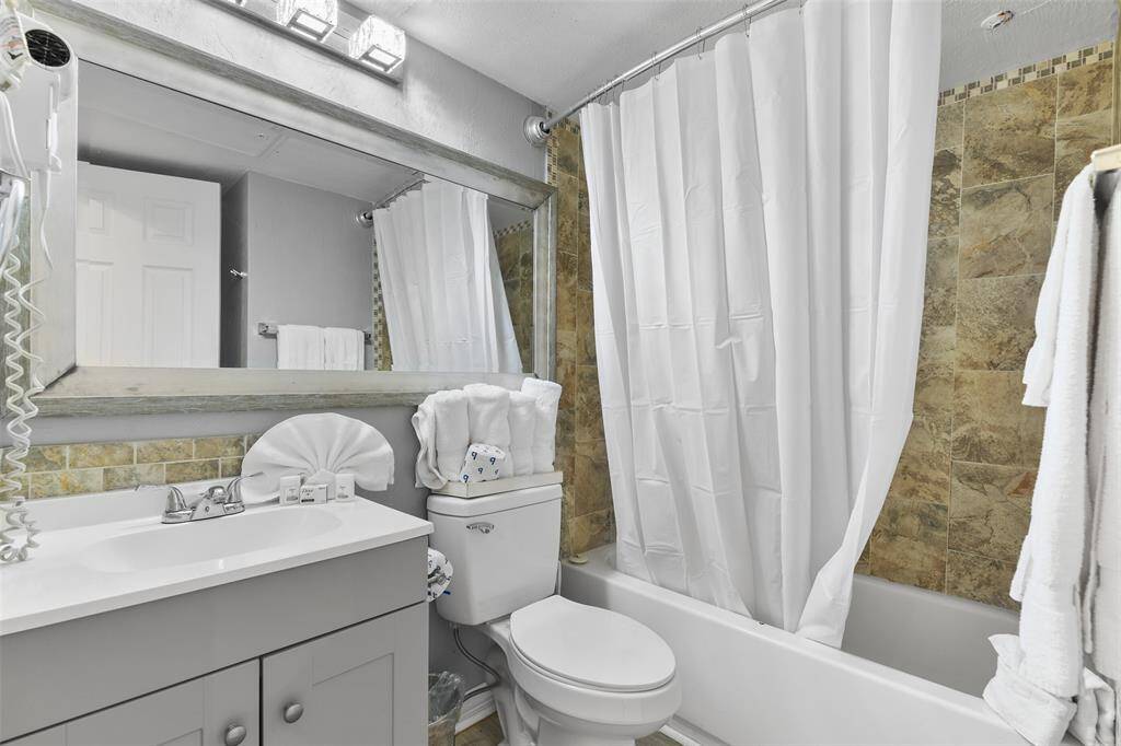 The bathroom features a stand-up shower and a well-appointed vanity area, offering a clean and functional space designed for comfort and convenience.